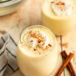 glasses of eggnog with cinnamon sticks.