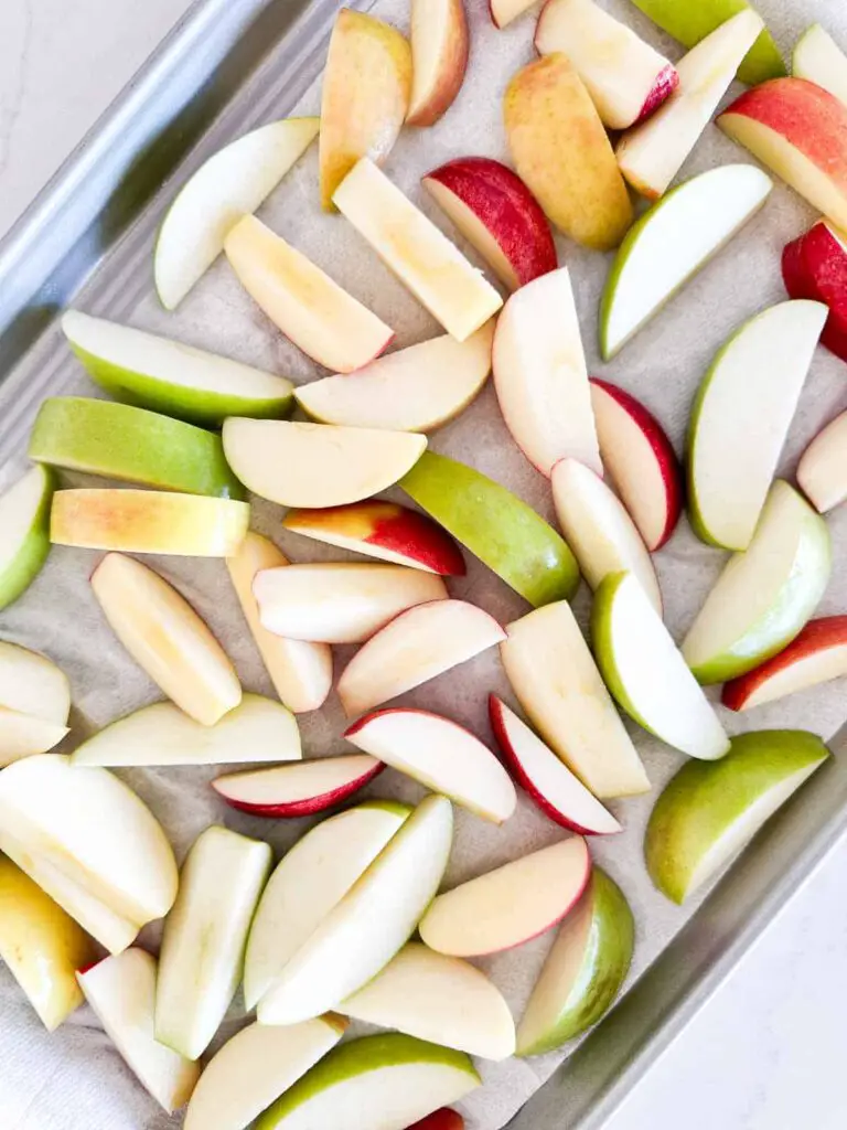 Sliced apples on a baking sheet.