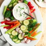 bowl of ranch dressing on platter of vegetables.