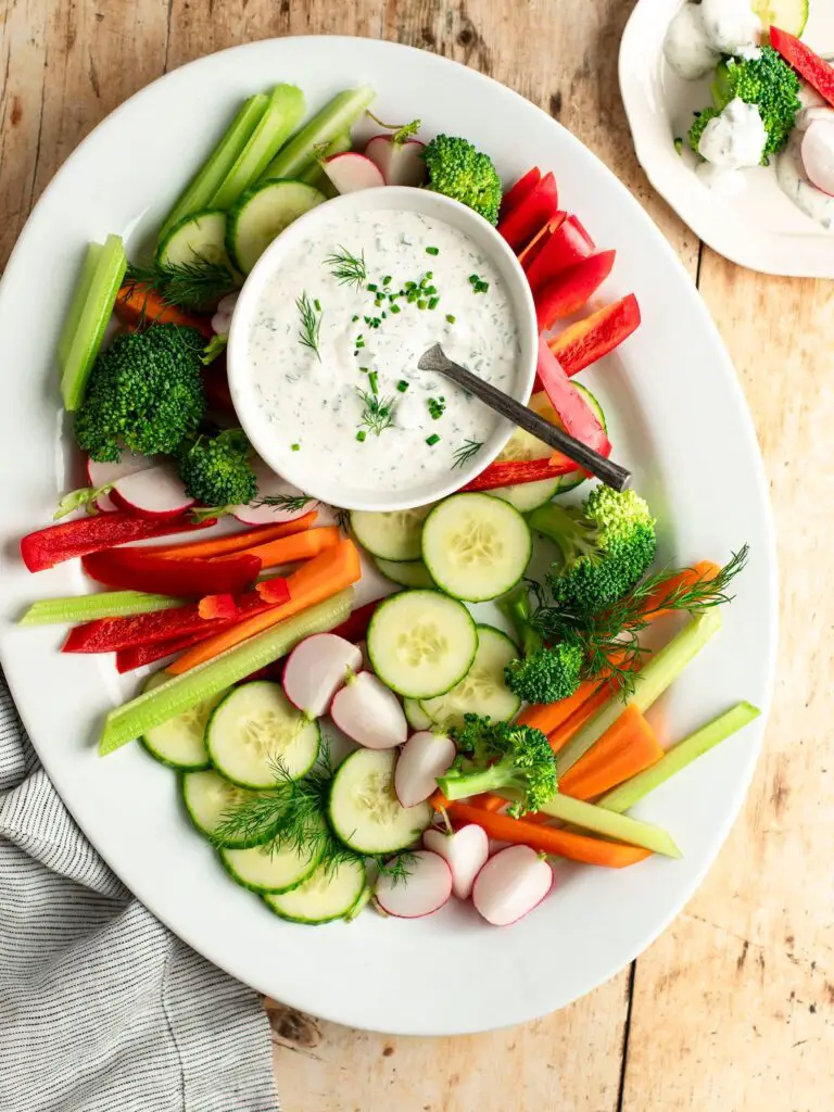 bowl of ranch dressing on platter of vegetables.