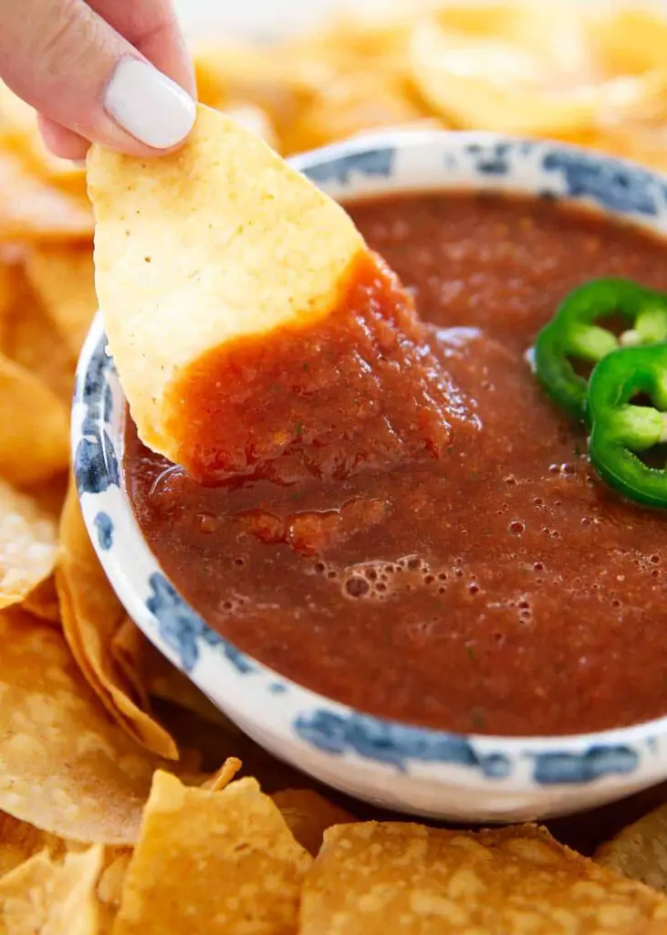 Dipping tortilla chip into salsa.