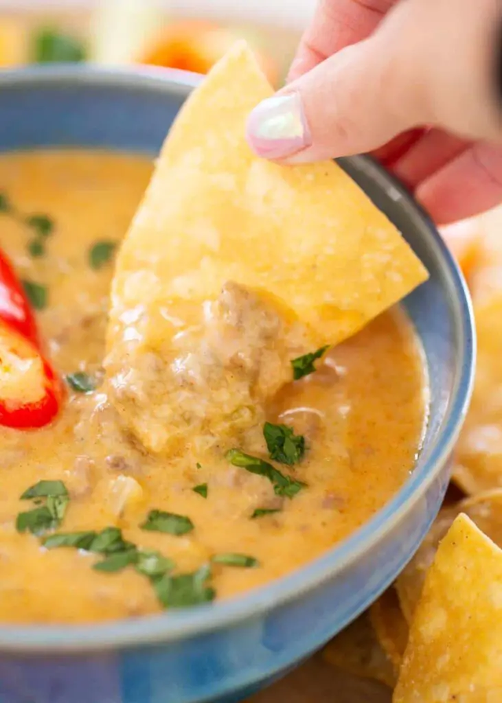 Dipping chip in cottage cheese queso.