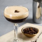 espresso martini garnished with coffee beans with cocktail shaker