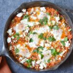 shakshuka in cast iron skillet with linen napkin.